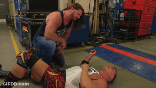 A Man Kneeling Down Next To A Man Laying On The Floor With A Shirt That Says Ohio GIF