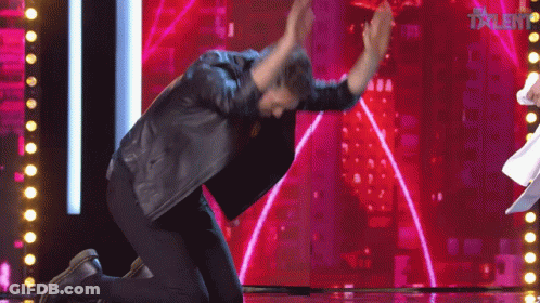 A Man Kneeling Down On A Stage With The Word Talent On The Screen GIF