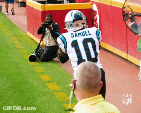 A Man Kneeling Down Taking A Picture Of A Football Player Wearing A Number 10 Jersey GIF