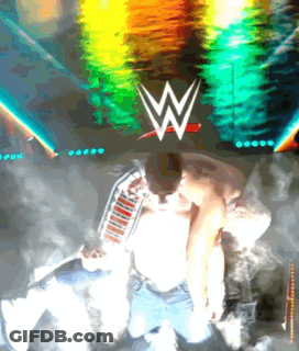 A Man Kneeling In Front Of A Wwe Logo GIF