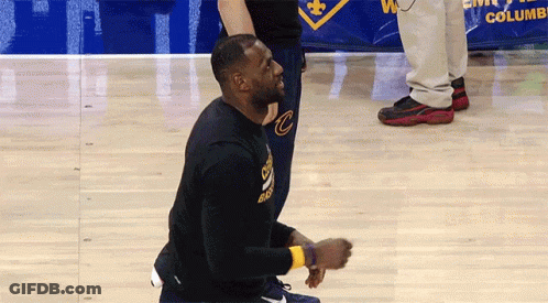 A Man Kneeling On A Basketball Court Wearing A Black Shirt With The Letter C On It GIF