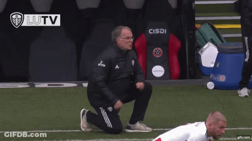 A Man Kneeling On A Soccer Field In Front Of A Cisdi Chair GIF