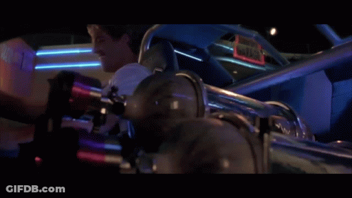 A Man Laughs While Sitting In A Car With A Sign That Says Gator GIF