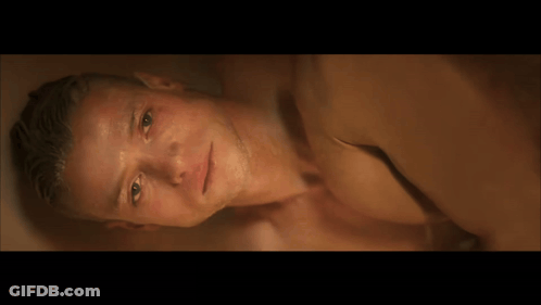 A Man Laying Down With His Hand On His Forehead GIF