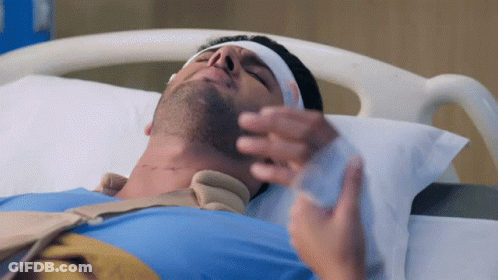 A Man Laying In A Hospital Bed With A Bandage On His Head GIF