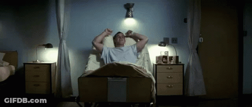 A Man Laying In A Hospital Bed With His Arms Outstretched GIF
