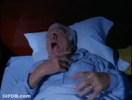 A Man Laying In Bed With His Mouth Open GIF