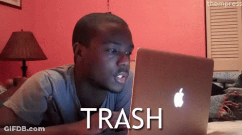 A Man Laying On A Bed Looking At A Laptop With The Word Trash Written On The Screen GIF