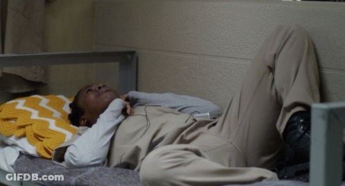 A Man Laying On A Bed With A Yellow Blanket GIF