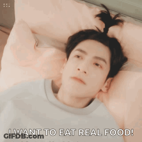 A Man Laying On A Bed With His Mouth Open And The Words I Want To Eat Real Food GIF