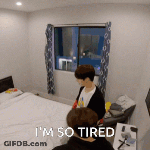 A Man Laying On A Bed With The Words " I 'M So Tired " Below Him GIF