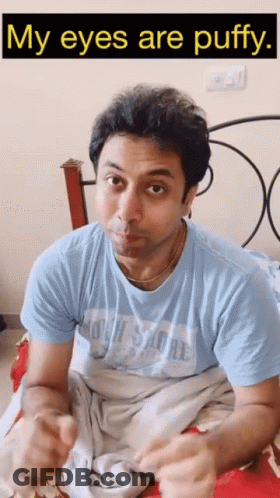 A Man Laying On A Bed With The Words " My Eyes Are Puffy " Below Him GIF