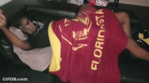 A Man Laying On A Couch With A Blanket That Says Florinsia GIF
