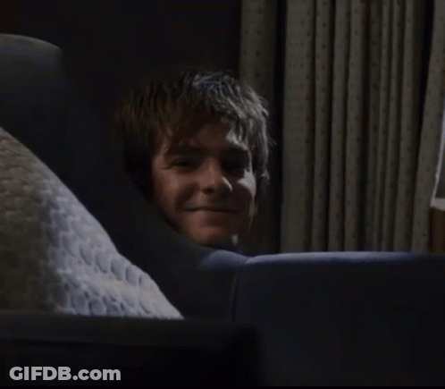 A Man Laying On A Couch With A Pillow That Says ' N.c.c. ' On It GIF
