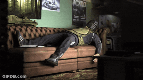A Man Laying On A Couch With A Poster That Says Mcx00 On The Wall Behind Him GIF