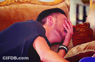 A Man Laying On A Couch With His Hand On His Face GIF