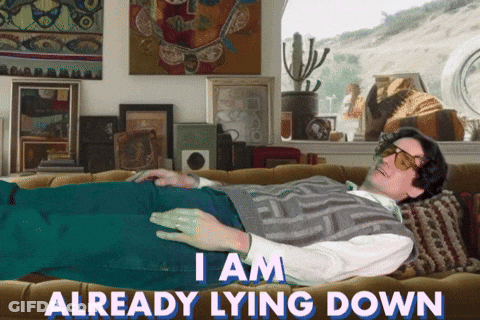 A Man Laying On A Couch With The Words " I Am Already Lying Down " GIF