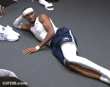 A Man Laying On The Floor With A Headband On GIF