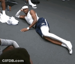 A Man Laying On The Floor With His Legs Crossed And A Headband On His Head GIF