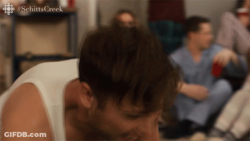 A Man Laying On The Floor With The Word Schitts Creek Written On The Bottom GIF