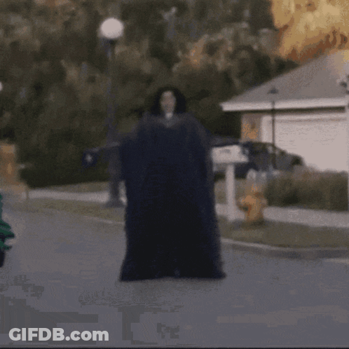 A Man Laying On The Ground In Front Of A House GIF