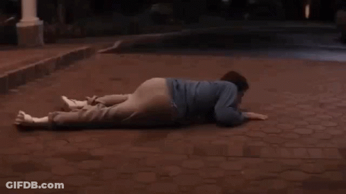 A Man Laying On The Ground In Front Of A White Car With The Word End Written On The Bottom GIF