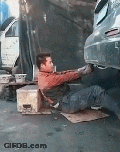 A Man Laying On The Ground Working On A Car With A License Plate That Says ' A ' On It GIF