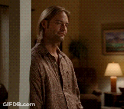 A Man Leaning Against A Wall In A Living Room GIF