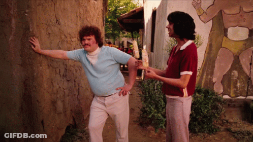 A Man Leaning Against A Wall With His Hand On It GIF