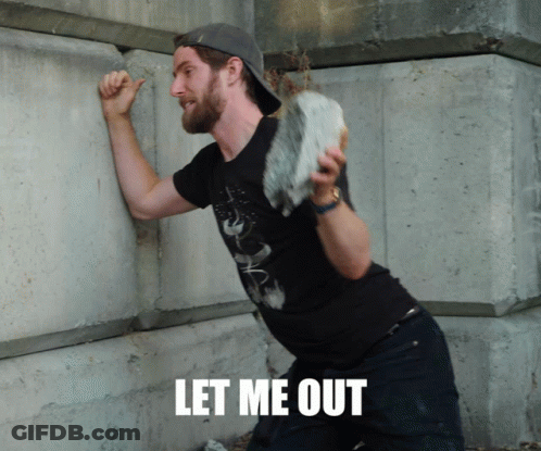 A Man Leaning Against A Wall With The Words Let Me Out Written On The Bottom GIF