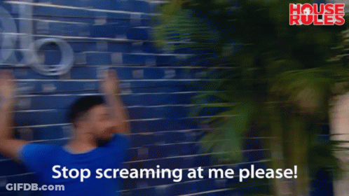 A Man Leans Against A Blue Brick Wall With The Words Stop Screaming At Me Please On The Bottom GIF