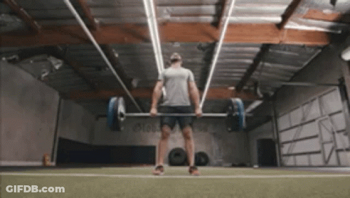 A Man Lifting A Barbell In A Gym GIF