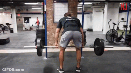 A Man Lifting A Barbell In A Gym Wearing A Shirt That Says " Athlete " GIF