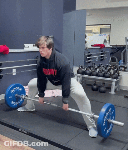 A Man Lifting A Barbell In A Gym With A Rogue Logo On The Barbell GIF
