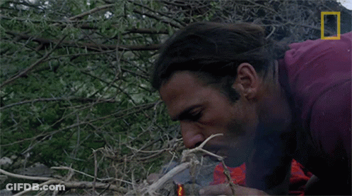 A Man Lighting A Fire With A National Geographic Logo In The Corner GIF