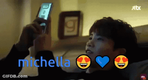 A Man Looking At A Cell Phone With The Name Michella On The Bottom Right GIF