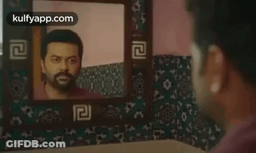 A Man Looking At His Reflection In A Mirror . GIF