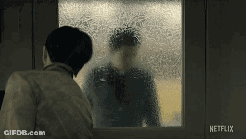 A Man Looking Out A Window With A Netflix Logo On The Bottom Right GIF