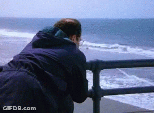 A Man Looking Out Over The Ocean From A Pier GIF