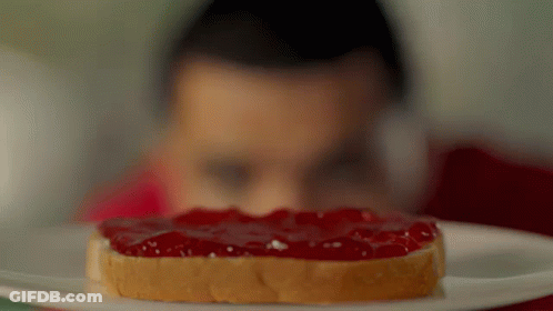 A Man Looks At A Slice Of Peanut Butter And Jelly Toast GIF