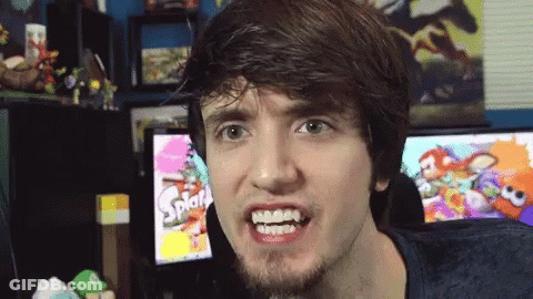 A Man Making A Funny Face In Front Of A Screen That Says Splat GIF