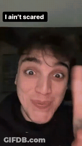 A Man Making A Funny Face With The Words " I Ain 'T Scared " Above Him GIF