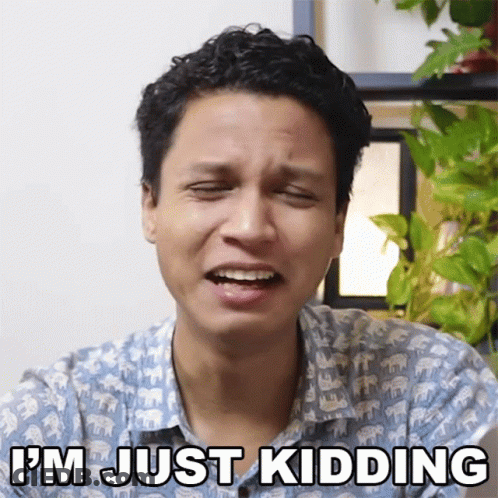 A Man Making A Funny Face With The Words I 'M Just Kidding Behind Him GIF