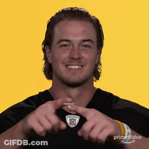 A Man Making A Heart Shape With His Hands In Front Of A Yellow Background GIF