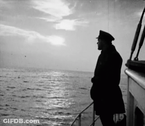A Man On A Boat Looking Out Over The Ocean GIF
