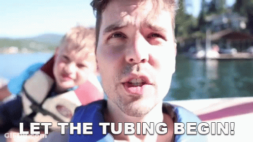 A Man On A Boat With The Words Let The Tubing Begin Below Him GIF