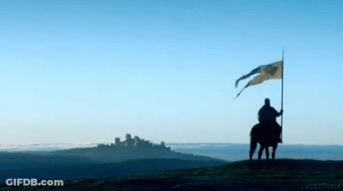 A Man On A Horse Holding A Flag In Front Of A Mountain GIF
