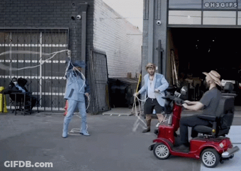A Man On A Mobility Scooter Is Playing With A Rope While Another Man Holds A Lasso GIF