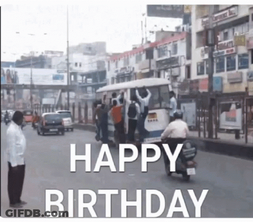 A Man On A Motorcycle Is Driving Down A Street With The Words Happy Birthday Written On It GIF