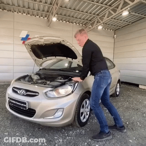 A Man Opens The Hood Of A Silver Hyundai GIF